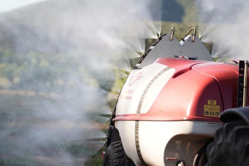 Imported mist blower spraying in an orchard